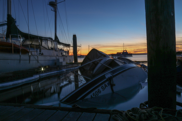 The deeply sunken boat, which was leaking oil, was required to sit in the bay for another night.
