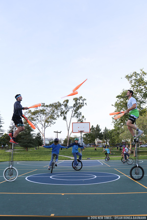 Von Jon (left) and Mark Wilder (right) juggle together atop 7-foot tall unicycle at Meadow Park.