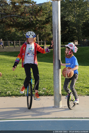 Beginning unicyclists start off with one hand on a pole or fence for balance.
