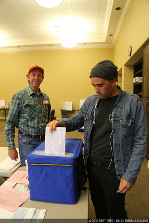 EMT Josh Cody drops his ballot while polling place Lead Inspector Bob Peak watches.