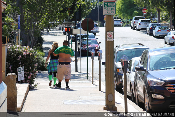 A reveler throws on a green shirt on his way to the bar.